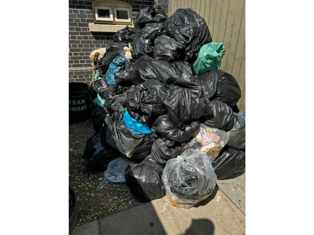 A large pile of full waste bags gathered at a storage point during the Woolsack Race